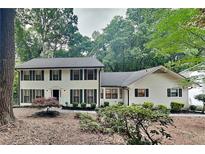 Charming two-story home featuring a well-manicured lawn and classic architectural design with dark shutters at 247 Millbrook Farm Rd, Marietta, GA 30068