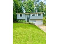 Charming home featuring a well-manicured lawn, light blue siding, and white garage door at 3544 Citrus Dr, Duluth, GA 30096