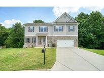 A stunning two-story house with brick accents, vinyl siding, shutters, and an attached garage at 1630 Eaglerock Dr, Suwanee, GA 30024
