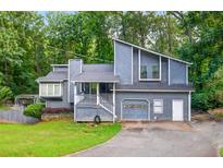 Charming two-story home with an attached garage and a well-maintained front yard at 3328 Hidden Bluff Trl, Snellville, GA 30039