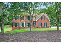 Charming brick home with manicured lawn and mature trees offering a picturesque setting at 2020 Ridge Gate Drive Dr, Cumming, GA 30041