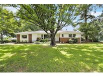 Charming home featuring a well-manicured lawn and a classic brick and white exterior at 2785 Toney Dr, Decatur, GA 30032