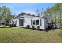 Charming single-story home with gray siding, dark shutters, well-manicured landscaping, and inviting entrance at 1251 Pierce Ave, Smyrna, GA 30080