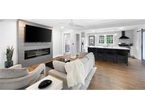 Open-concept living room with fireplace, modern design, and seamless flow into the kitchen at 1251 Pierce Ave, Smyrna, GA 30080
