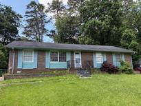 Charming single-story home with brick facade, light blue shutters, and well-maintained front yard at 1487 Colony East Cir, Stone Mountain, GA 30083