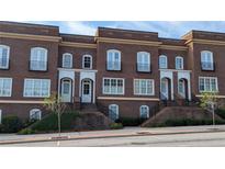 Charming brick townhomes with white trim and arched doorways, offering a classic and inviting facade at 5139 Peachtree Road, Chamblee, GA 30341