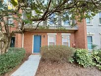 Charming two-story brick townhome with a blue front door and mature landscaping at 3533 Mulberry Way, Duluth, GA 30096