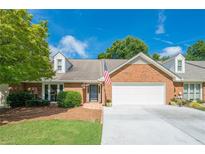 Charming brick home featuring an attached garage, manicured lawn, and an inviting front entrance at 535 Brickleberry Ln, Roswell, GA 30075