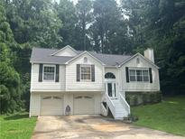 Charming home featuring a two-car garage, classic black shutters, and a welcoming front entrance at 95 Heartwood Xing, Dallas, GA 30157
