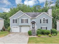 Charming two-story home with a two-car garage and well-manicured lawn and front yard at 1735 Silver Way, Lithia Springs, GA 30122