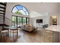 Bright living room featuring a modern sofa, elegant lighting, and an impressive arched window with views at 790 North Ne Ave # 209, Atlanta, GA 30306