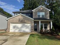 Inviting two-story home with a manicured lawn, a brick facade, and a two-car garage at 1601 Dosk Ave, Lawrenceville, GA 30044