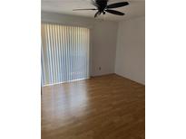 Bright bedroom with wood floor, ceiling fan and large window with vertical blinds at 1867 Myrtle Dr # 5, Atlanta, GA 30311
