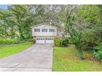 Traditional home featuring a two-car garage, green shutters, and a well-manicured front lawn at 2047 Cliffton Ter, Snellville, GA 30039