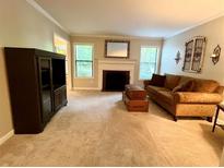 Inviting living room with a cozy fireplace, neutral carpet, and a comfortable brown sofa at 1612 Huntingdon, Atlanta, GA 30350