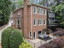 Beautiful brick home featuring a patio with outdoor seating and lush landscaping at 1292 Lenox Park Ne Blvd, Brookhaven, GA 30319