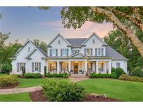 Stunning two-story home with white siding, shutters, manicured lawn, and inviting front porch at 150 Trinity Farm Dr, Canton, GA 30115