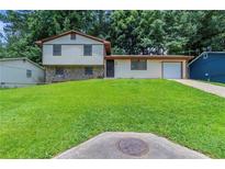 Charming split-level home with well-manicured lawn, stone accents, and attached garage in a desirable neighborhood at 2247 Cherokee Valley Dr, Lithonia, GA 30058