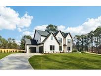 Stunning two-story home featuring a manicured lawn, black trim, and an attached two-car garage at 3735 Tamiami Trl, Cumming, GA 30041
