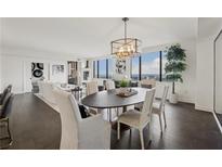 Bright and airy dining room with modern chandelier and floor-to-ceiling windows offering stunning city views at 75 14Th Ne St # 3820, Atlanta, GA 30309
