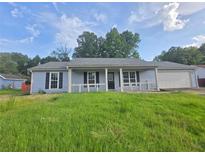 Charming single-story home featuring a covered front porch and attached two-car garage at 563 Fieldgreen Dr, Jonesboro, GA 30238