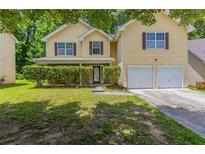 Charming two-story home with a well-maintained lawn and a two-car garage at 260 Redding Rdg, Atlanta, GA 30349