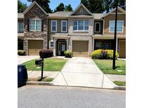 Charming townhome with a well-manicured lawn, driveway, and attached garage in a desirable neighborhood at 3645 Mcclaren Way, Lawrenceville, GA 30044