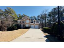 Traditional two-story home with manicured lawn, driveway, and an attached two-car garage at 4569 Campenille Trce, Suwanee, GA 30024