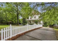 Charming two-story home with a white picket fence and lush landscaping, creating a welcoming curb appeal at 2177 Mauldin Nw St, Atlanta, GA 30318