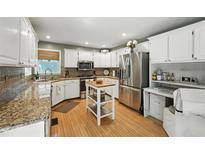 Bright kitchen features granite countertops, stainless steel appliances, and a mobile island at 912 Spring Vly, Woodstock, GA 30189