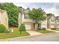 Charming townhome features a well-manicured lawn, a one-car garage, and inviting curb appeal at 1643 Jackson Nw Way, Atlanta, GA 30318