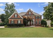 Beautiful brick two-story home featuring manicured lawn and mature trees at 390 Wilde Green Dr, Roswell, GA 30075