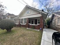 Charming brick home with covered front porch and landscaped front yard at 472 Parkway Ne Dr, Atlanta, GA 30308
