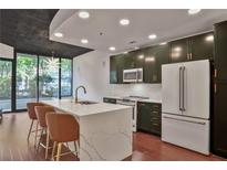 Modern kitchen features a large island, stainless steel appliances, and stylish cabinetry with gold hardware at 855 Peachtree Ne St # 1108, Atlanta, GA 30308