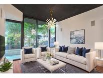 Bright living room with modern lighting, white furniture, and a view of the lush outdoors at 855 Peachtree Ne St # 1108, Atlanta, GA 30308