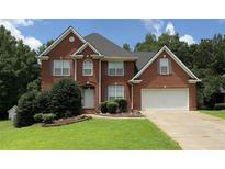 Traditional red brick two-story home with an attached two car garage and manicured front lawn at 350 Glynnshire Ct, Covington, GA 30016