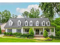 Charming home featuring a welcoming front porch, dormer windows, manicured lawn, and mature landscaping, creating inviting curb appeal at 505 Junction Pt, Roswell, GA 30075