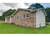 Charming brick home with white trim, surrounded by a lush green lawn and mature trees at 24 Echo Ridge Dr, Powder Springs, GA 30127