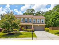 Charming two-story home with lush green lawn and mature trees in a desirable neighborhood at 3876 Thackary Dr, Powder Springs, GA 30127