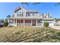 Charming two-story home featuring a welcoming front porch, gray siding, and a well-maintained lawn on a sunny day at 737 Wilkes Dr, Loganville, GA 30052