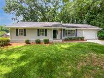 Charming single-story home with a well-maintained lawn and inviting curb appeal in a treed neighborhood at 540 Stockwood Dr, Woodstock, GA 30188