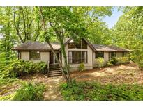 Charming home featuring a gable roof and lots of windows surrounded by mature trees at 1832 Tree Top Ct, Marietta, GA 30062