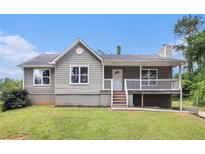 Charming home featuring a gray exterior, front porch, and well-maintained lawn at 28 Fawn Ct, Sharpsburg, GA 30277