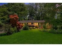 Well-manicured lawn and charming exterior, framed by mature trees create an inviting curb appeal at 5400 Francis Ave, Stone Mountain, GA 30087