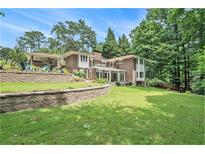 Expansive brick home with terraced yard, beautiful landscaping, and mature trees at 1620 Stonecliff Dr, Decatur, GA 30033