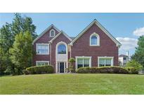 Beautiful brick two-story home with well-manicured lawn and mature trees on a sunny day at 2268 Orleans Ave, Marietta, GA 30062
