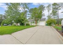 Charming single-story home with a long driveway, attached garage, and lush front lawn at 1249 Riva Ridge Dr, Norcross, GA 30093