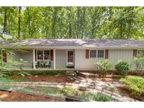 Charming single-story home with a covered front porch and natural stone walkway amid wooded surroundings at 2880 Foothill Trl, Marietta, GA 30066