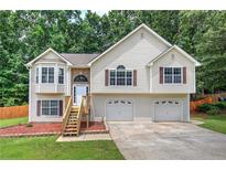 Charming split-level home featuring stone accents, wood shutters, and a two-car garage at 121 Paradise Circle, Douglasville, GA 30134