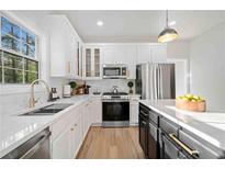 Bright kitchen boasts white cabinets, stainless steel appliances, and a stylish island with quartz countertops at 139 Thunder Ridge Ln, Acworth, GA 30101